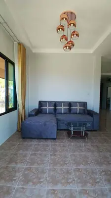 a blue couch in a living room with a chandelier at Janjira sea view pool villa in Ban Ko Kwang