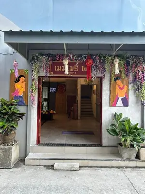 a entrance to a building with flowers on it at SawasdeeCiao Patong Guesthouse in Patong Beach