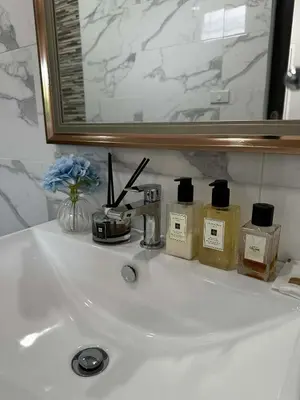 a bathroom sink with bottles of soap and a mirror at Kamala Zen house 2BR 15 min walk to beach in Kamala Beach