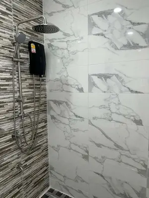 a bathroom with a shower with white marble tiles at Kamala Zen house 2BR 15 min walk to beach in Kamala Beach