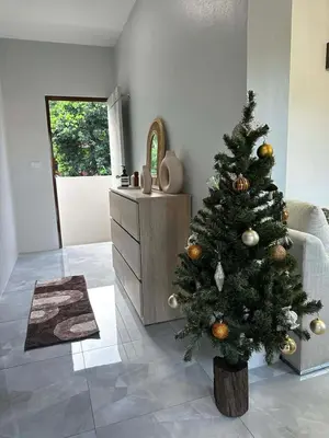 a christmas tree in a living room next to a dresser at Kamala Zen house 2BR 15 min walk to beach in Kamala Beach
