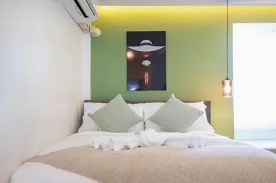 a bedroom with a white bed with green walls at Heaven pool villa reach beach in 3 mins bangla10m in Patong Beach