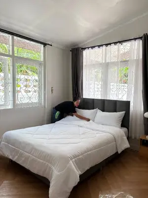 a man laying on a bed in a bedroom at 3BR Family Villa - 1 km to Chalong Pier with WiFi in Chalong