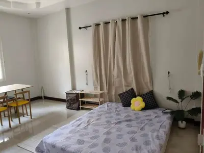 a bedroom with a bed and a table and chairs at Joyful House3 in Thalang