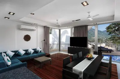 a living room with a blue couch and a tv at Mountain View 4BR Pool Villa Minutes to Kamala in Kamala Beach