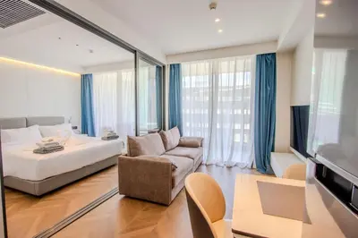 a bedroom with a bed and a couch and a chair at KORA 257 D One-Bedroom Residence in Phuket Town