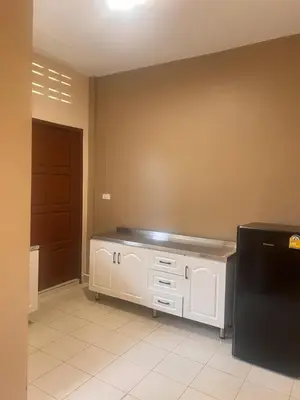 a kitchen with white cabinets and a black refrigerator at Latte Home Krabi ลาเต้โฮมกระบี่ in Ao Nang Beach