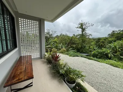 a porch with a wooden bench and some plants at Natureville cozy home near Samet Nangshe