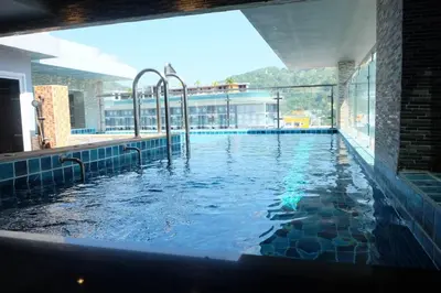 a swimming pool in a building with a large window at Private Jacuzzi Pool Suite near walking street in Patong Beach