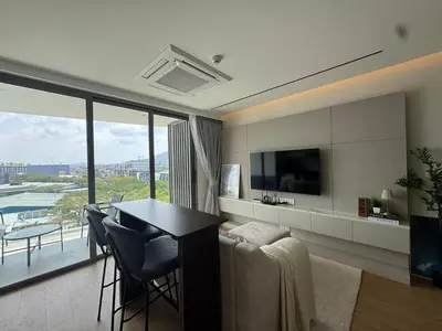 a living room with a table and a large window at Modern 1BR Condo Top Floor Pool, Cinema & Fast WiFi Next to Boat Avenue in Phuket