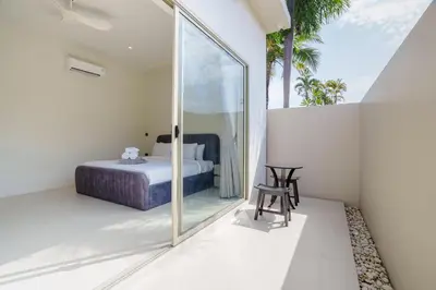 a bedroom with a bed and a sliding glass door at New Celine Villa Private Pool Near Beaches in Ban Saiyuan (1)
