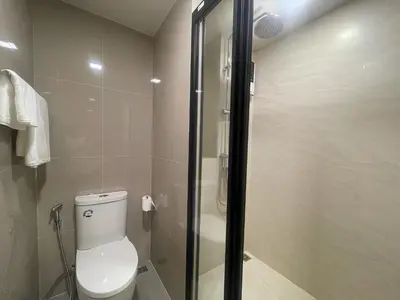 a bathroom with a toilet and a glass shower at Rest&Rise Phuket in Ban Rangeng