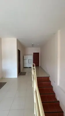 an empty room with a staircase and a kitchen at rawai cozy hostel in Rawai Beach