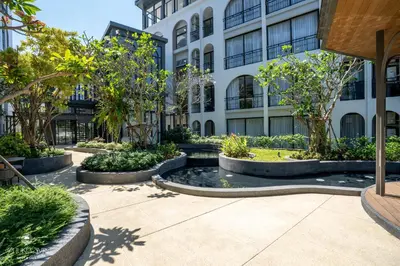a courtyard with a fountain in front of a building at Harmony Condominium Phuket in Ban Saiyuan (1)
