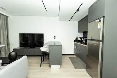 a kitchen with a couch and a table in a room at Harmony Condominium Phuket in Ban Saiyuan (1)