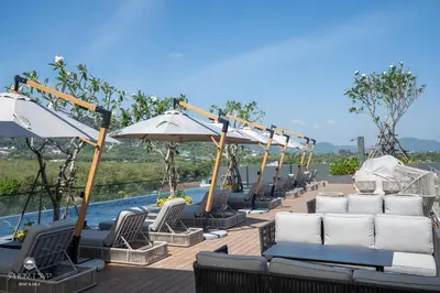 a row of chairs and umbrellas next to a pool at Harmony Condominium Phuket in Ban Saiyuan (1)