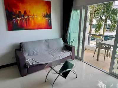 a living room with a couch and a painting on the wall at One BR 24 in Ban Karon