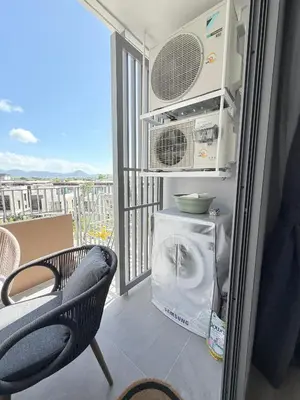 a refrigerator with a washing machine and a chair on a balcony at Skypark 4th floor Mountain View terrace in Laguna Phuket