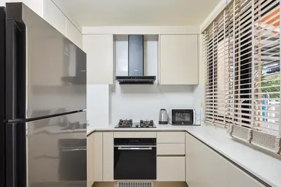 a kitchen with white cabinets and a black appliance at Townhouse Laguna Park 3 bedrooms in Laguna Phuket
