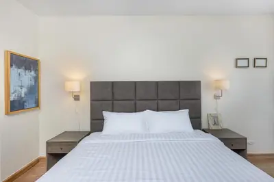 a bedroom with a large white bed with two tables at Townhouse Laguna Park 3 bedrooms in Laguna Phuket