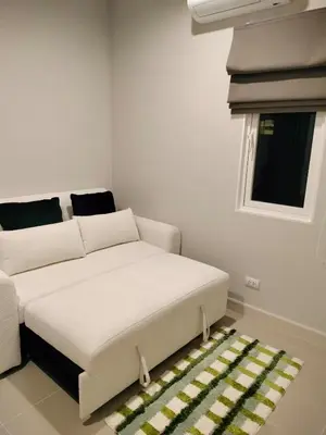 a living room with a bed and a window at Phuket Paklok Cozy Home in Ban Pa Khlok