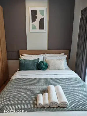 a bed with two rolled towels on it at Phuket Paklok Cozy Home in Ban Pa Khlok