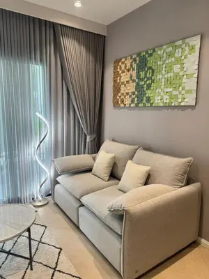 a living room with a couch in front of a window at Bali Essence, The Title BangTao in Bang Tao Beach
