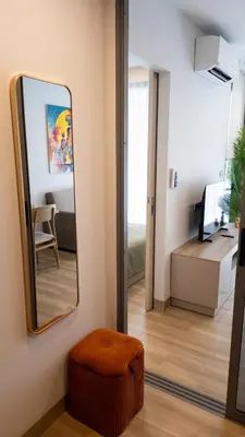 a mirror in a room with a chair and a desk at Natural Harmony - SkyPark Celeste in Laguna Phuket