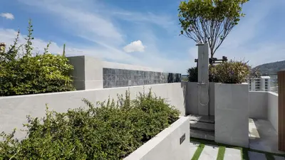 a concrete fence with plants on top of a house at Natural Harmony - SkyPark Celeste in Laguna Phuket