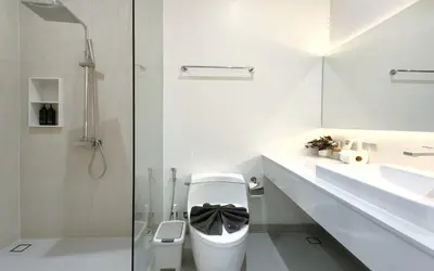 a white bathroom with a toilet and a sink at Luxury Private Christina Pool Villa in Ban Phak Chit