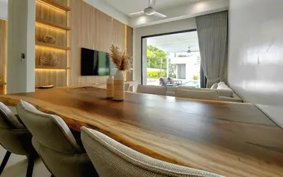 a large wooden table in a living room with chairs at Luxury Private Christina Pool Villa in Ban Phak Chit