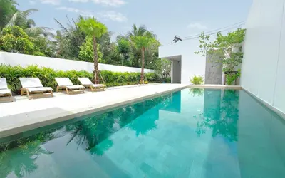a swimming pool with two chairs and a house at Luxury Private Christina Pool Villa in Ban Phak Chit