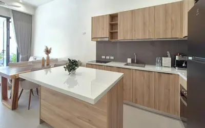 a kitchen with a white counter top and wooden cabinets at Luxury Private Christina Pool Villa in Ban Phak Chit