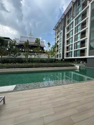 a swimming pool in front of a building at Пляж Бангтао Резиденция Ozon in Laguna Phuket