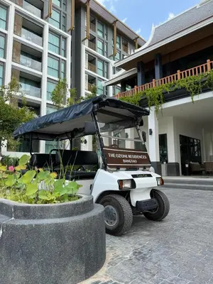 a golf cart with a black canopy in front of a building at Пляж Бангтао Резиденция Ozon in Laguna Phuket