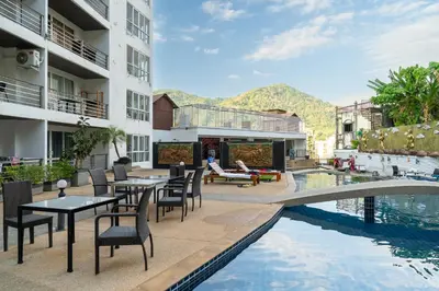 a hotel patio with tables and chairs next to a pool at Patong hillside Condo with pool, bar, parking in Patong Beach