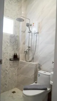 a bathroom with a shower and a toilet in it at Tiny house bangtao in Ban Thalat Choeng Thale