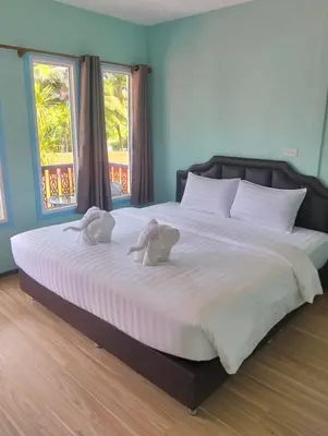 a bedroom with a large bed with two towels on it at The Nap Koh Yao Yai in Ban Nai Wat