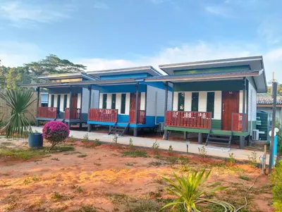 a blue house with red benches in front of it at The Nap Koh Yao Yai in Ban Nai Wat