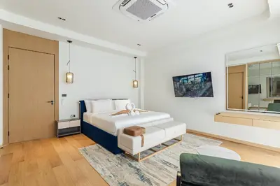 a white bedroom with a bed and a couch at PRAIA Residence 5BR - Bangtao in Ban Pak Lak
