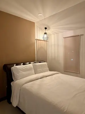 a bedroom with a bed with white sheets and a light at KONE- 3BR Private Pool Villa Kathu near Patong in Ban Kathu