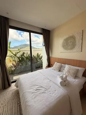 a bedroom with a large white bed with a window at Chareen Pool Villa in Ban Khlong Haeng
