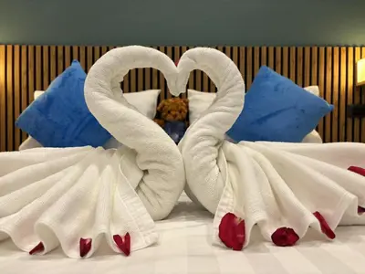two swans made out of towels on a bed at Nova Inn in Patong Beach