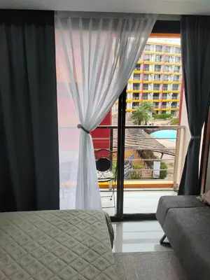 a bedroom with a window with a view of a building at 777 Condo Phuket in Ban Mai Salae
