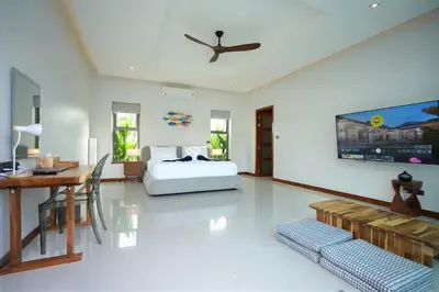 a bedroom with a bed and a desk and a table at Villa Tropicana - Luxury 4 Bedroom Villa in Rawai Beach
