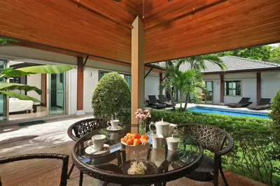 a table with a bowl of fruit on a patio at Baan Bua Estate Villas by TropicLook in Nai Harn Beach