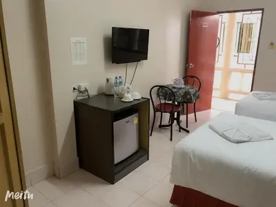a room with a tv and a room with two beds at Baan Boa Guest House in Patong Beach
