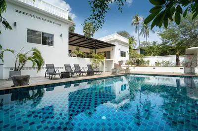 a swimming pool in front of a house at Grand 5BR Pool Villa Sea la Vie in Rawai Beach