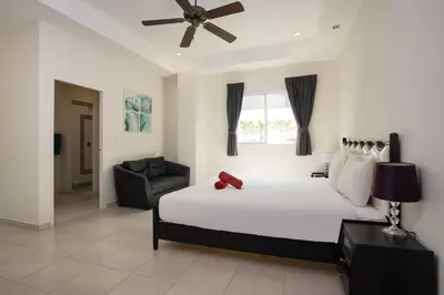 a bedroom with a bed and a ceiling fan at Grand 5BR Pool Villa Sea la Vie in Rawai Beach