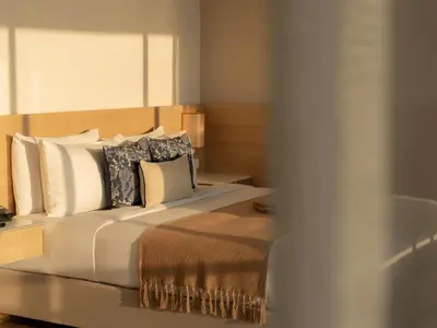a bedroom with a large bed with pillows at Andaman Beach Hotel Phuket - Handwritten Collection by Accor in Patong Beach